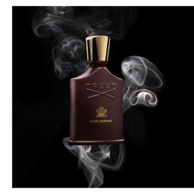 A dark brown perfume bottle with a gold cap is surrounded by swirling white smoke against a black background, displaying the words CREED, a gold crest, and OUD ZARIAN on its front.