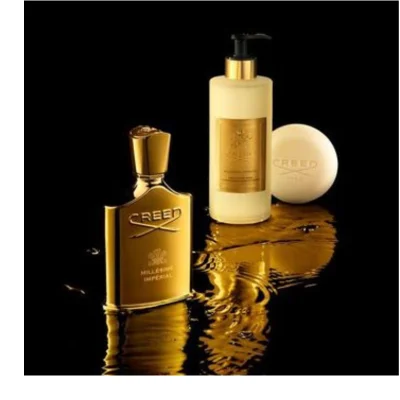 A gold Creed Millésime Impérial perfume bottle, a tall gold Creed Millésime Impérial lotion bottle with a black pump, and a round gold Creed soap bar are displayed on a reflective, wet black surface.