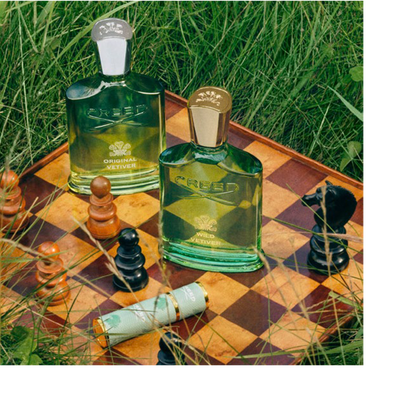 Close-up of a black bottle cap with an embossed crest logo above a clear glass bottle neck.