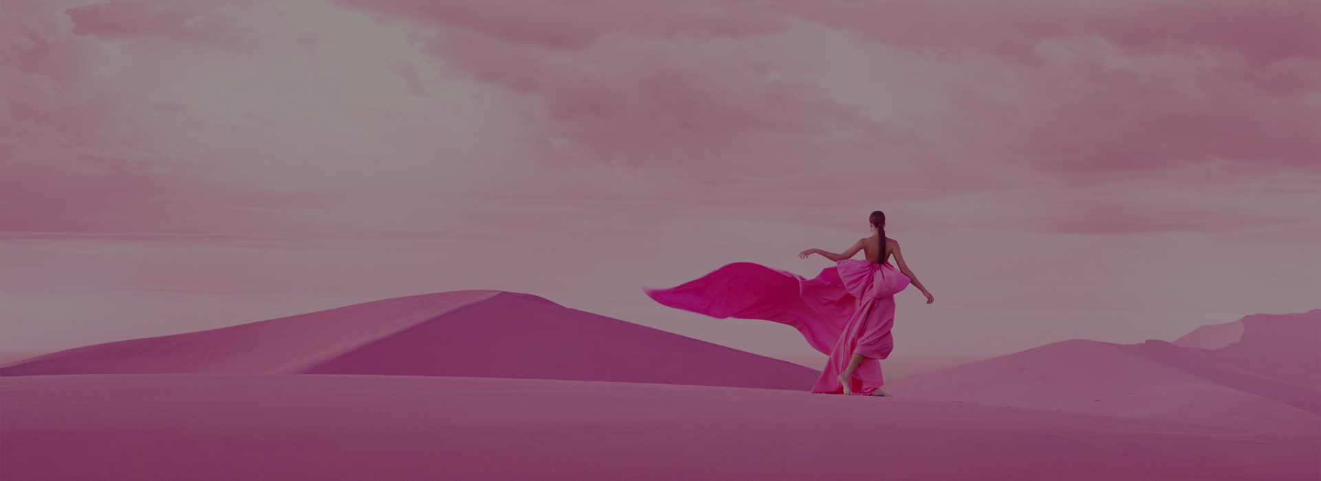 Woman in pink dress walking in the desert